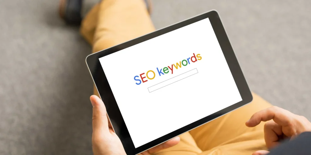 Persona utilitzant una tauleta per cercar paraules clau SEO i optimitzar el posicionament web.