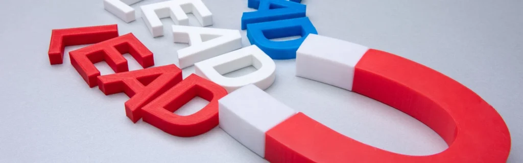 Representació visual d'un 'lead magnet' amb la paraula LEAD en lletres 3D de varis colors i un gran imán que l'atrau.