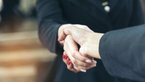 Dues mans encaixant-se, simbolitzant la confiança i la fidelització entre empresa i client.