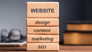 Bloques de madera con palabras website, design, content, marketing y SEO, representando los pilares del marketing digital.