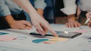 Professionals fent un análisis de dades amb gràfics circulars i tauleta per medir l'èxit d'implementació de HubSpot en negocis B2B.