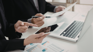 Dos professionals treballant en equip sobre un escriptori blanc amb eines digitalitzades