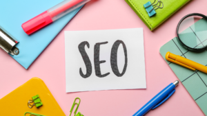 Concepte d'optimització per a motors de cerca (SEO) representat amb útils d'oficina i una nota escrita a mà