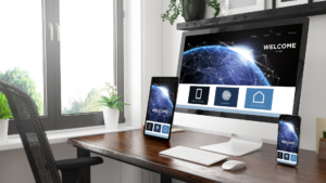 Ejemplo de diseño web responsivo en múltiples dispositivos (monitor, tablet y móvil) sobre un escritorio de oficina iluminado.